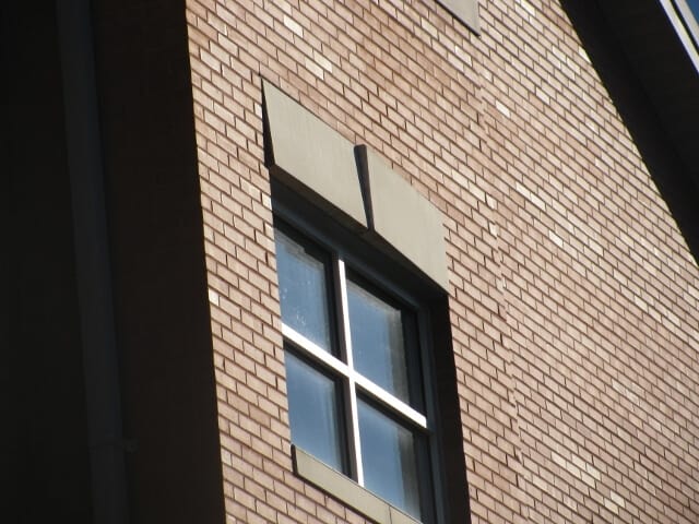 a window on a building with brick walls.